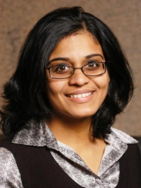 Vidya Sundar is a woman with shoulder length wavy black hair who wears glasses.